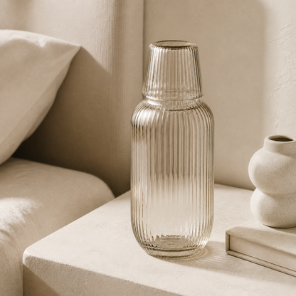 Ribbed glass carafe styled on a warm neutral bedside table
