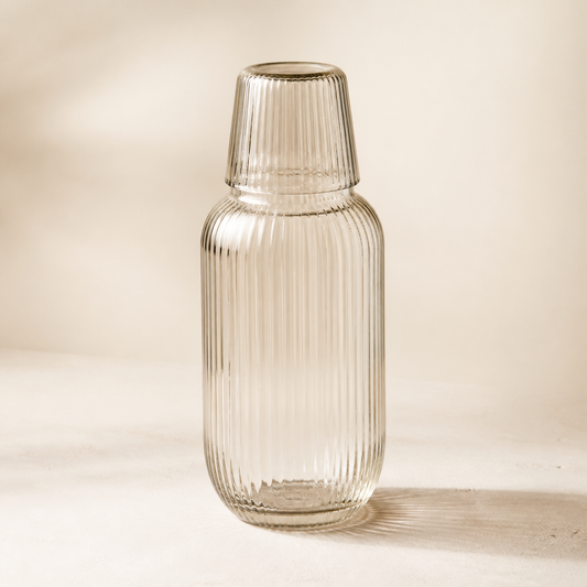 Clear ribbed Averlomia Glass Carafe with matching tumbler on an ivory background
